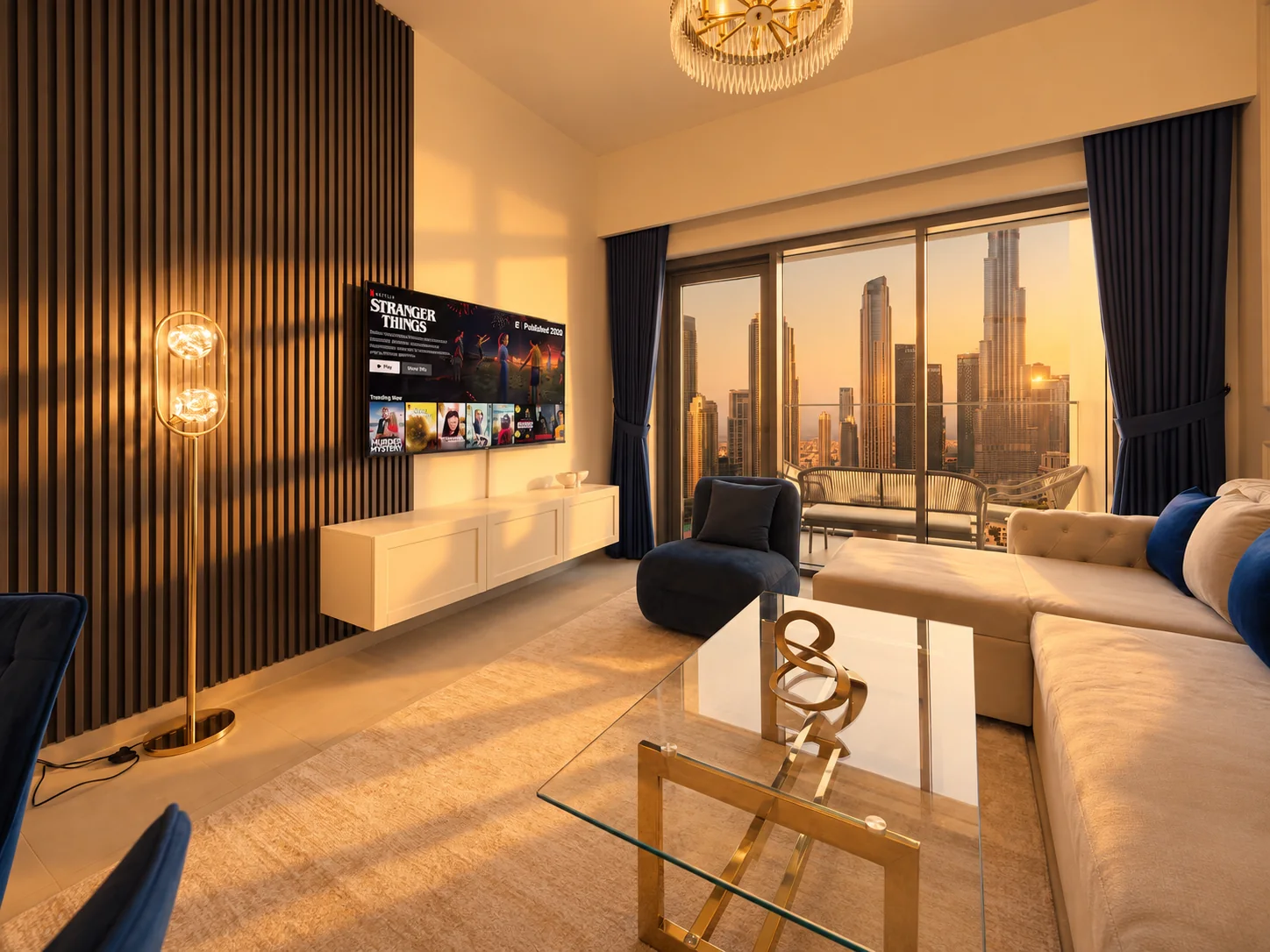 Living room with navy accents opening onto a city-view balcony